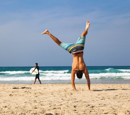 Guy doing handstand on the beach