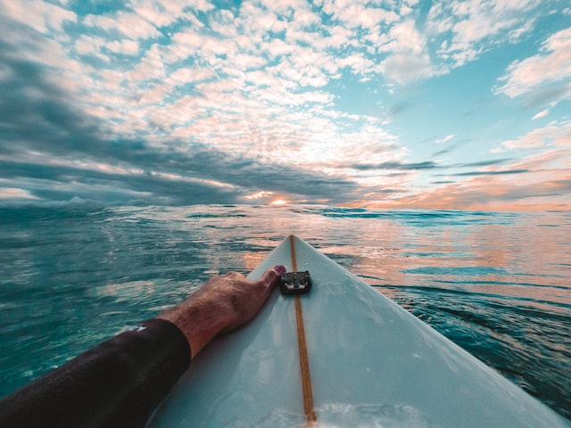 surfer swimming on their board going out to sea