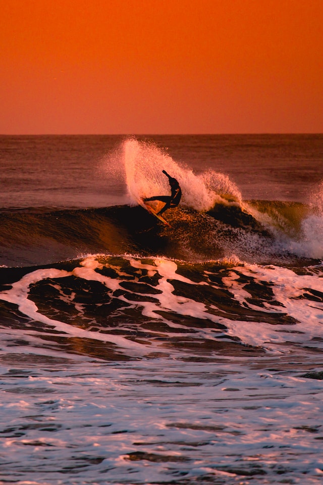 surfer at dusk riding a wave as a metaphor for a HubSpot portal audit